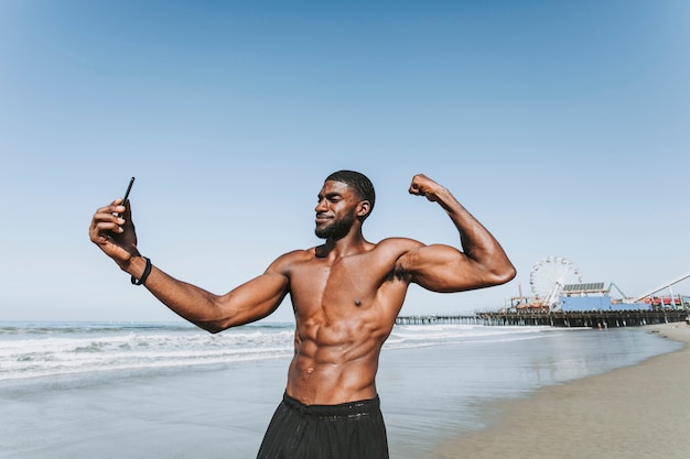 Hombre en forma tomando un selfie por el muelle de Santa Mónica