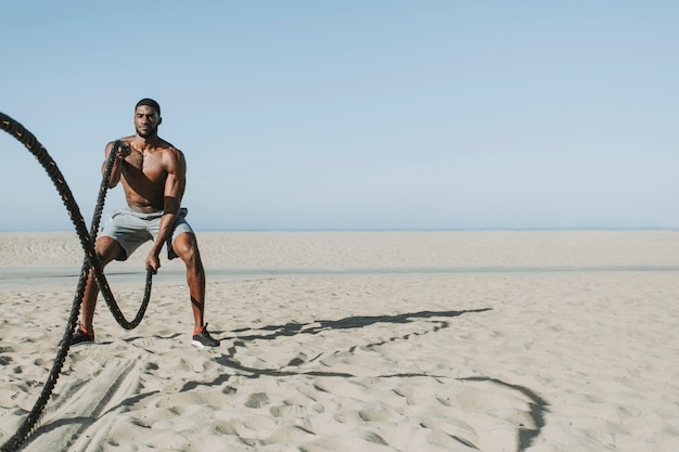 Hombre en forma trabajando con cuerdas de batalla