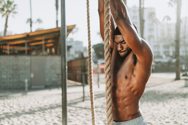 Hombre en forma trabajando con cuerdas