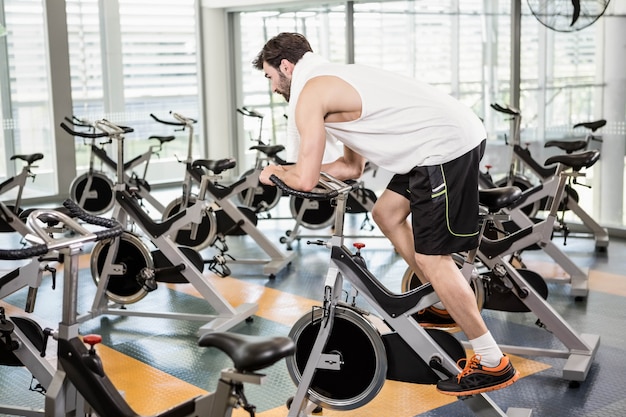 Hombre en forma usando bicicleta en el gimnasio