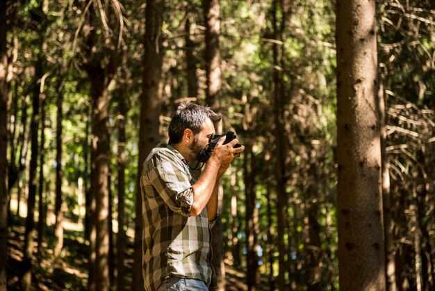 Hombre fotografiando en el bosque