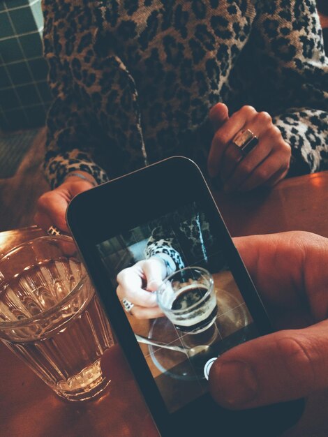 Foto hombre fotografiando café en la mesa con un amigo