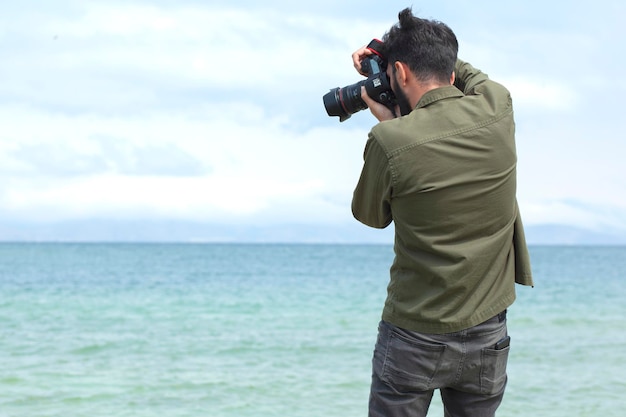 Foto el hombre está fotografiando el mar.