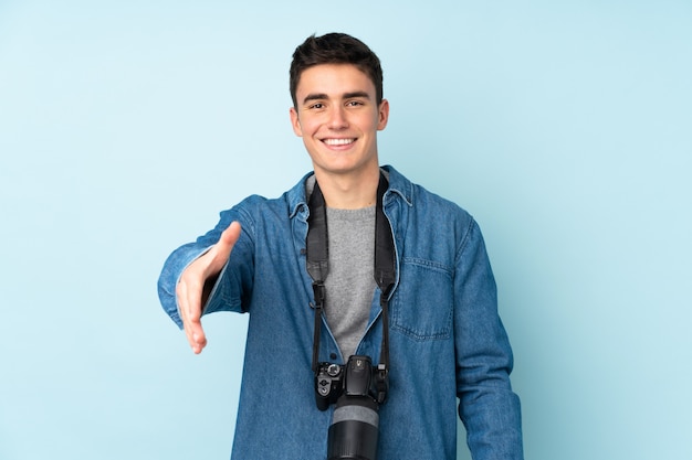 Hombre fotógrafo adolescente aislado en azul