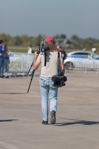 Un hombre fotógrafo caminando por la zona y sosteniendo su equipo.