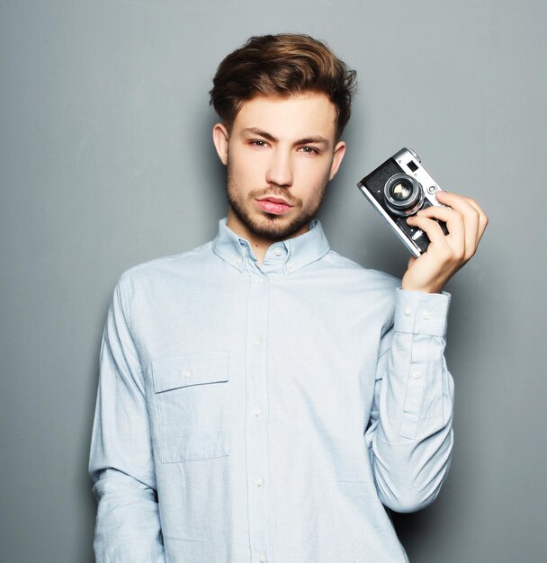 Hombre de fotógrafo de moda hipster con cámara retro