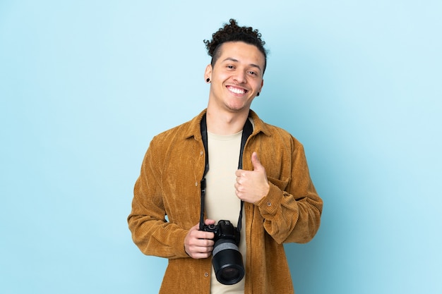 Foto hombre fotógrafo sobre azul aislado dando un pulgar hacia arriba gesto