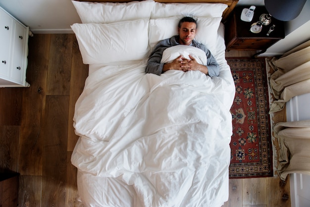 Hombre francés durmiendo solo en la cama