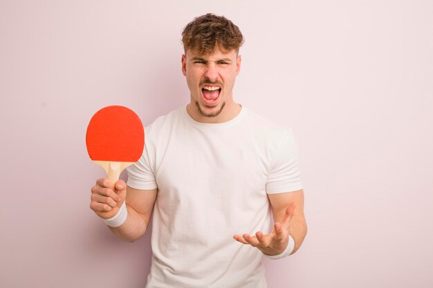 Hombre fresco joven que parece enojado molesto y frustrado concepto de ping-pong