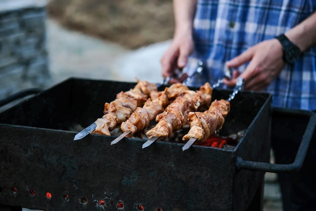 Un hombre fríe una barbacoa de carne a las brasas Carne a la brasa a las brasas Pollo a la barbacoa