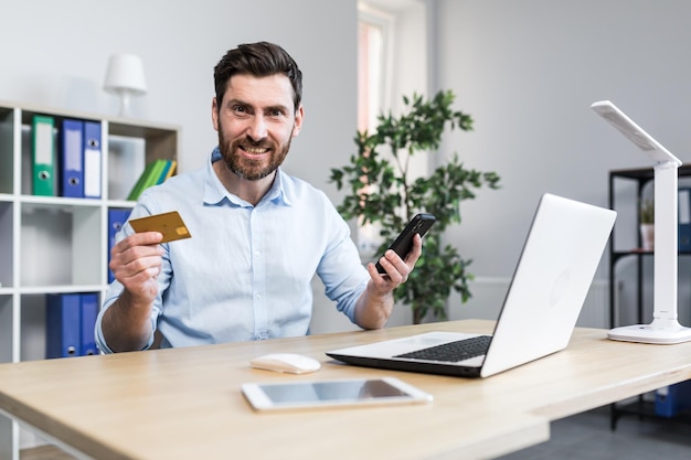 Hombre frustrado y enojado en la oficina tratando de hacer una compra en una tienda en línea un hombre de negocios con una tarjeta de crédito bancaria enojado recibió un error bancario