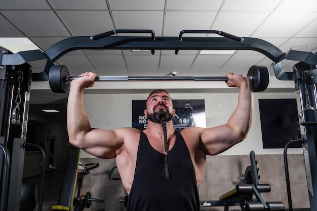 El hombre fuerte está entrenando en el gimnasio.