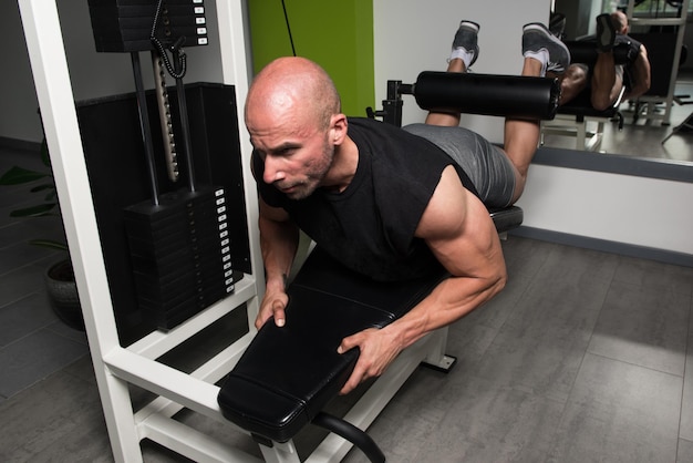 Hombre fuerte en el gimnasio y ejercicio de cuádriceps y glúteos en la máquina Muscular culturista atlético Fitness modelo ejercicio