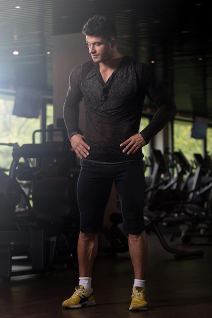 Hombre fuerte en gimnasio de fondo de camiseta negra