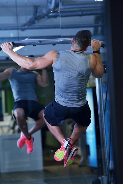 Un hombre fuerte y guapo haciendo ejercicio en el gimnasio