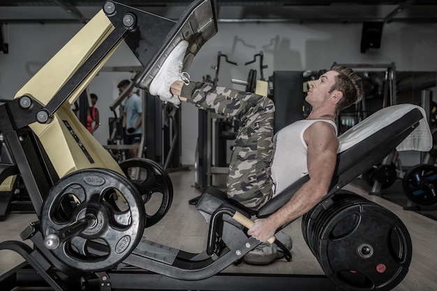 Hombre fuerte haciendo ejercicio en la máquina en el gimnasio