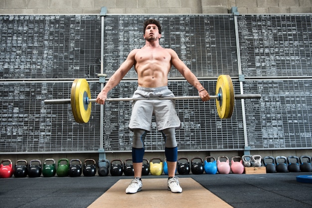 Foto hombre fuerte levantando pesas pesas