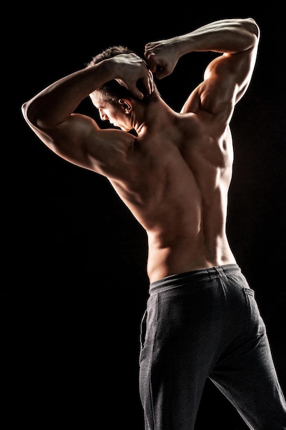 Hombre fuerte mostrando abdominales perfectos, hombros, bíceps, tríceps y ch