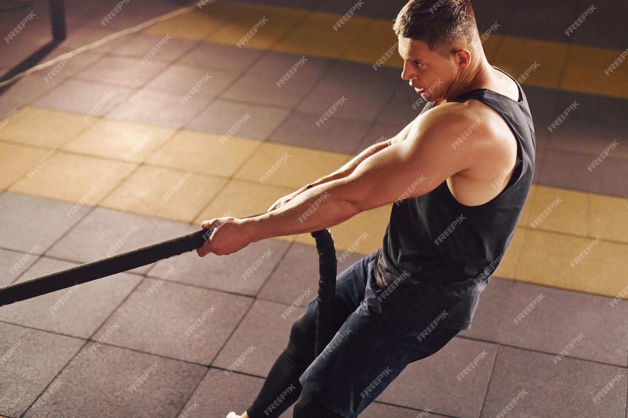 Un hombre fuerte con ropa deportiva tiene un día de entrenamiento en el  gimnasio.