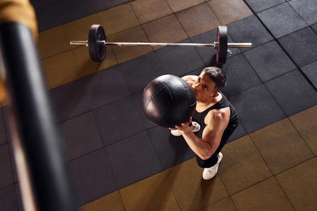 Un hombre fuerte con ropa deportiva tiene un día de entrenamiento en el gimnasio.