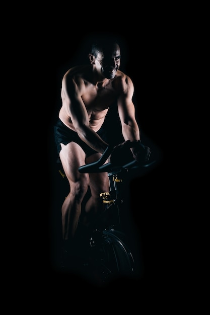 Hombre fuerte usando la bicicleta estática