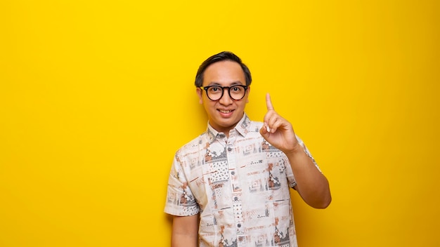 Foto un hombre con gafas y una camisa blanca apunta hacia arriba