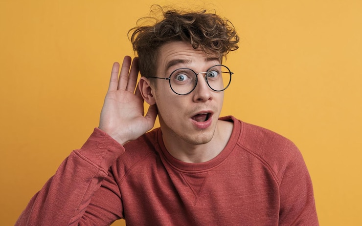 un hombre con gafas en la cara está usando una camisa roja con la palabra en ella
