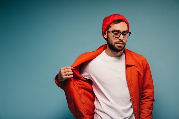 Hombre con gafas y casualidad se quita la chaqueta naranja.