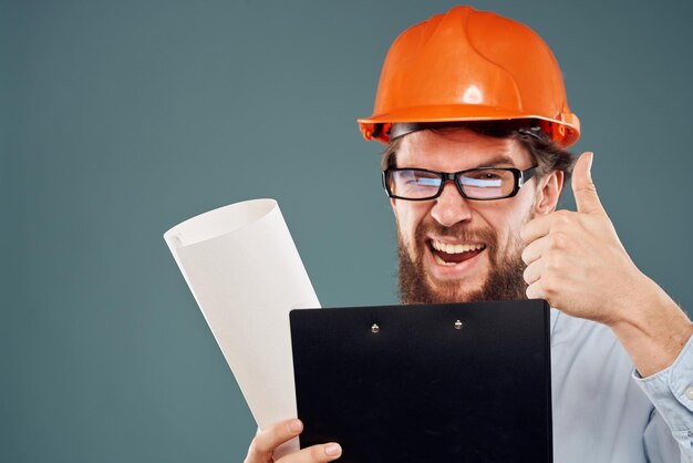 Hombre con gafas con documentos casco naranja trabajo de seguridad construcción