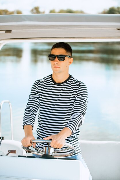 Hombre con gafas navegando en un barco