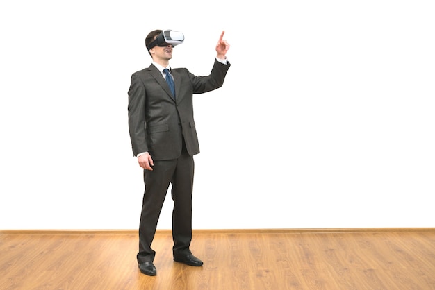 El hombre con gafas de realidad virtual gesticulando sobre el fondo de la pared blanca