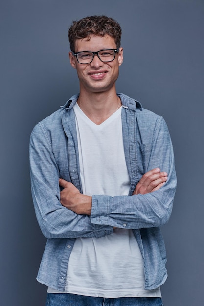 Hombre con gafas sobre un fondo gris