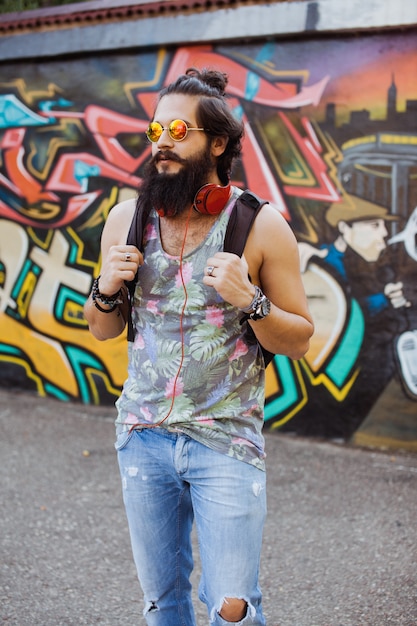 Hombre con gafas de sol y unos auriculares en el cuello