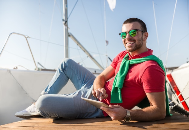 Un hombre con gafas de sol miente y sonríe.