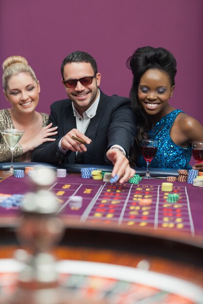 Hombre con gafas de sol con mujeres en la ruleta