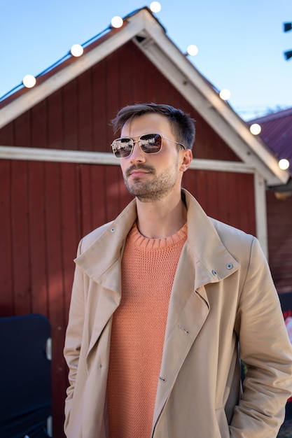 Hombre con gafas de sol de pie frente a una casa decorada