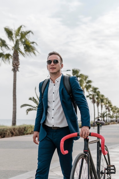 Foto hombre con gafas de sol sosteniendo su bicicleta afuera