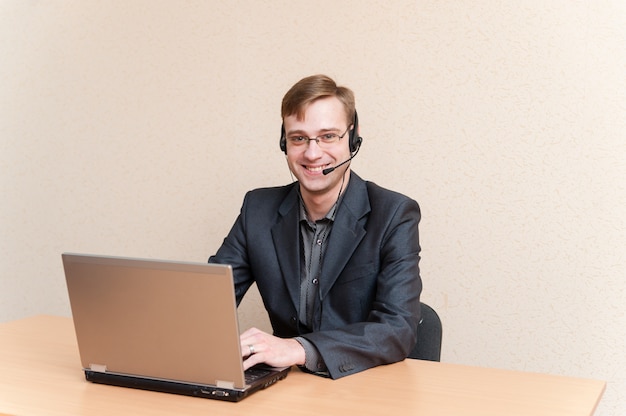 Hombre con gafas trabaja para laptop