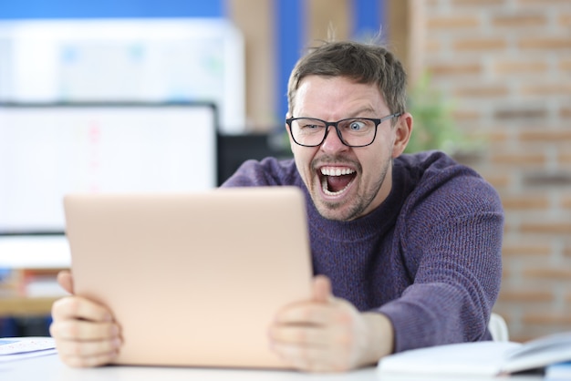 Hombre con gafas de vista mirando a la computadora portátil. Concepto de trabajo exitoso