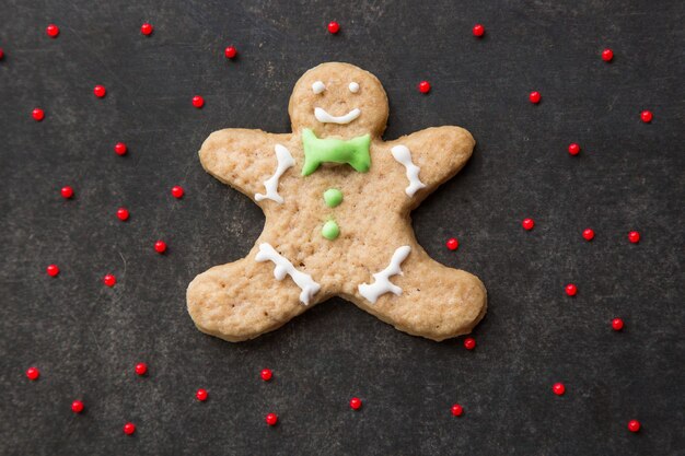 Foto hombre de la galleta de jengibre de navidad sobre fondo oscuro decoración tradicional de galletas de vacaciones caseras