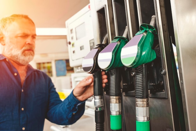 Foto hombre en la gasolinera llenando el tanque de su camión con diesel hasta el nivel superior antes de un largo viaje