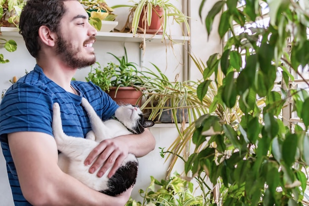 Hombre con gato mirando por la ventana