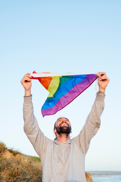 hombre gay ondeando la bandera lgbt