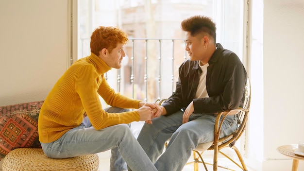 El hombre gay toma la mano de su pareja para comunicar algo.