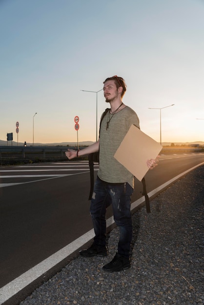 Foto hombre gestando mientras está de pie en la carretera contra el cielo