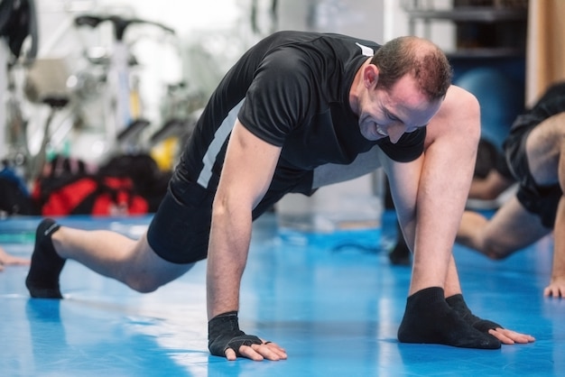 Hombre de gimnasio calentando en el gimnasio. Preparando el combate de kick boxing.