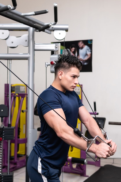 Foto hombre en el gimnasio levantando pesas con entrenamiento fuerte