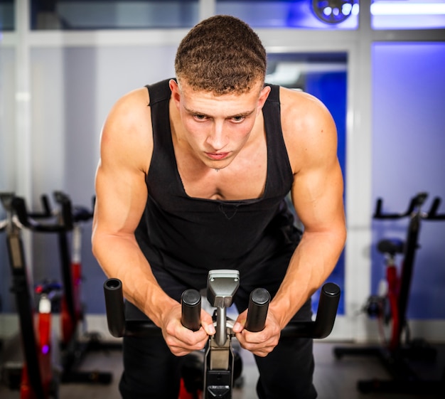 Hombre girando en bicicleta en un gimnasio