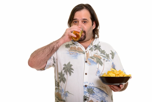 Foto hombre gordo caucásico bebiendo cerveza y sosteniendo un tazón de patatas fritas listo para vacaciones