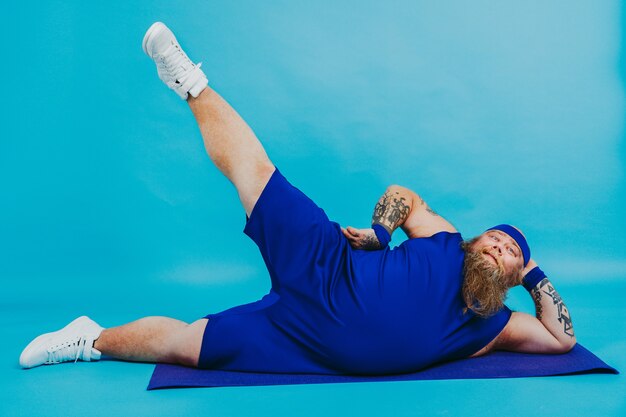 Hombre gordo divertido haciendo algunos ejercicios deportivos